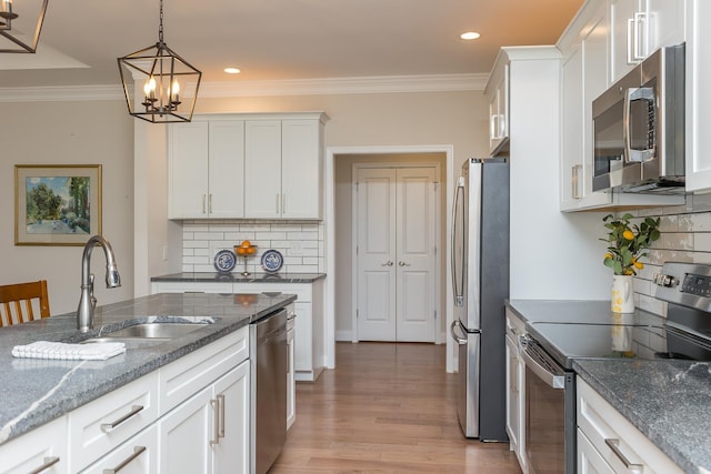 33 Silver Maple Cv, Fishersville, VA 22939 - kitchen featuring appliances with stainless steel finishes, a sink, white cabinets, light wood-style floors, and decorative backsplash