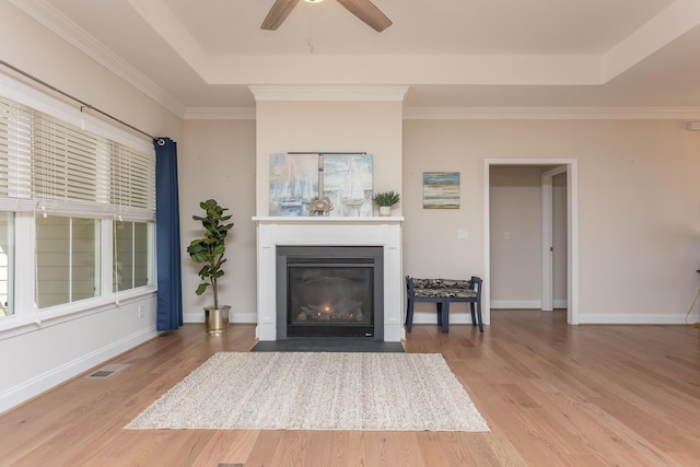 33 Silver Maple Cv, Fishersville, VA 22939 - living area featuring a ceiling fan, wood finished floors, a fireplace with flush hearth, a tray ceiling, and crown molding