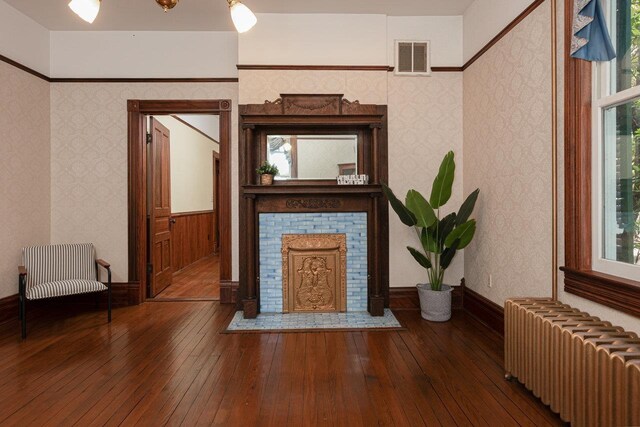557 Wayne Ave S, Waynesboro, VA 22980 - unfurnished living room featuring radiator, a tile fireplace, hardwood / wood-style floors, and wallpapered walls