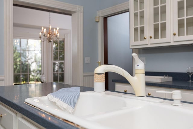 557 Wayne Ave S, Waynesboro, VA 22980 - detailed view of a chandelier, white cabinetry, glass insert cabinets, a sink, and hanging light fixtures