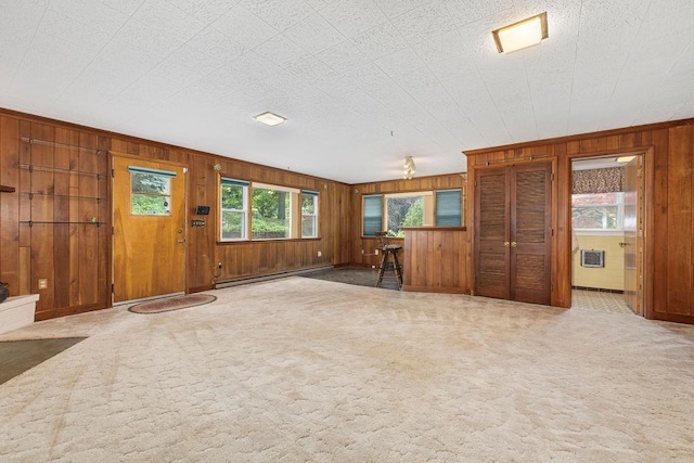 188 Middlebrook Rd, Staunton, VA 24401 - unfurnished living room featuring a baseboard radiator, wood walls, plenty of natural light, carpet flooring, and crown molding