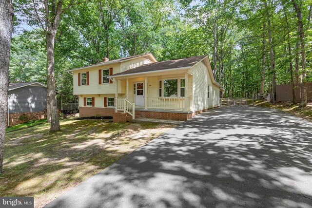 447 Laurel Ave, Fredericksburg, VA 22408 - split level home featuring asphalt driveway, covered porch, and a chimney