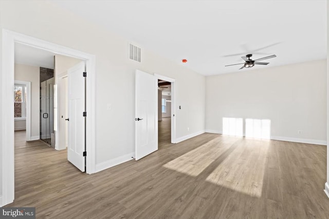 empty room with wood finished floors, baseboards, and ceiling fan