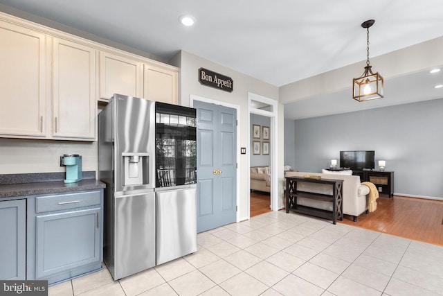 5502 Joshua Tree Cir, Fredericksburg, VA 22407 - kitchen featuring hanging light fixtures, light tile patterned flooring, open floor plan, stainless steel fridge, and dark countertops