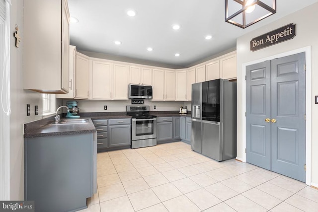 5502 Joshua Tree Cir, Fredericksburg, VA 22407 - kitchen with recessed lighting, light tile patterned floors, a sink, dark countertops, and appliances with stainless steel finishes