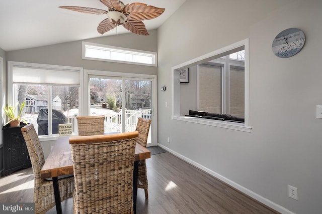dining area featuring vaulted ceiling, plenty of natural light, wood finished floors, baseboards, and ceiling fan