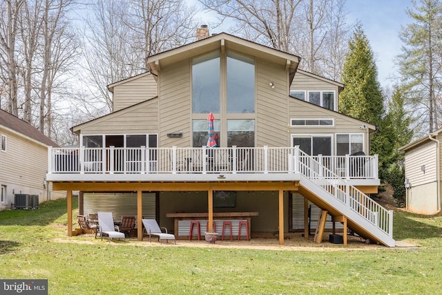 rear view of property featuring a sunroom, stairway, and a deck
