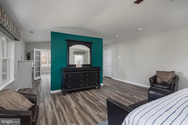 bedroom with wood finished floors, baseboards, and lofted ceiling