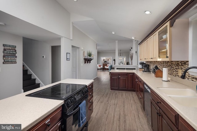 kitchen with black range with electric stovetop, light countertops, a sink, recessed lighting, and lofted ceiling