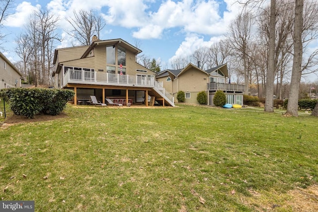 rear view of house featuring stairway, a wooden deck, a yard, and a chimney