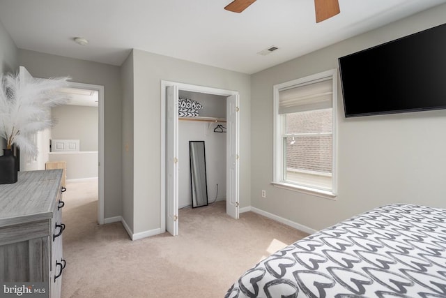 bedroom with light carpet, baseboards, a closet, and a ceiling fan