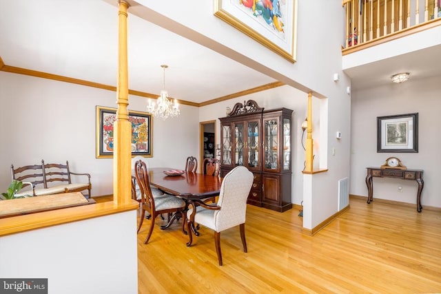 695 Whippoorwill Ln, Shipman, VA 22971 - dining room featuring light wood finished floors, a chandelier, crown molding, baseboards, and decorative columns