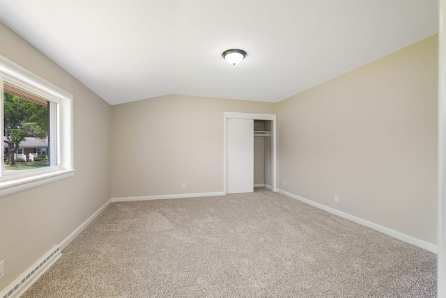 100 Monument Ave, Harrisonburg, VA 22801 - unfurnished bedroom featuring light carpet, lofted ceiling, a closet, and baseboards