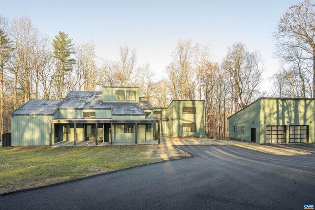 view of front of home featuring a front lawn, driveway, and a detached garage