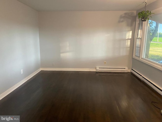  - spare room with baseboard heating, dark wood-style flooring, baseboards, and a baseboard radiator