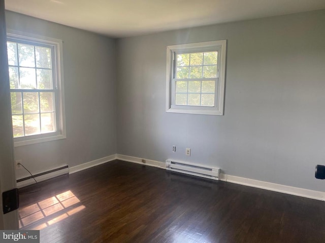  - spare room featuring baseboard heating, plenty of natural light, and dark wood-style flooring