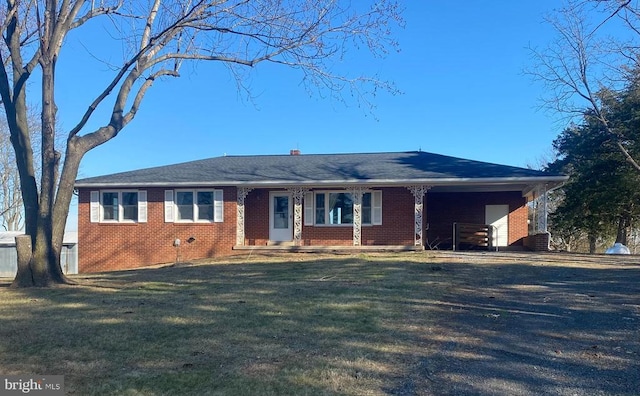  - ranch-style house featuring brick siding, a front yard, a carport, and driveway