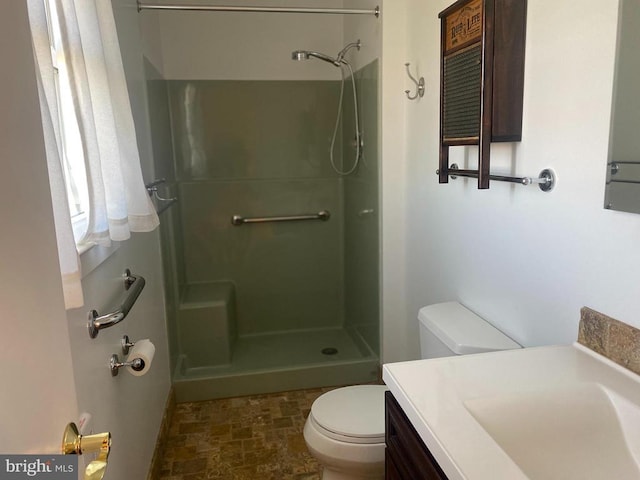  - full bathroom featuring toilet, stone finish floors, a shower, and vanity