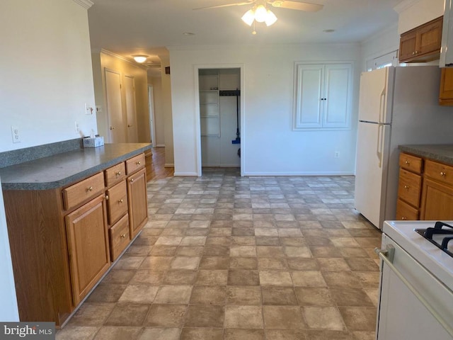  - kitchen featuring white appliances, a ceiling fan, dark countertops, brown cabinetry, and baseboards