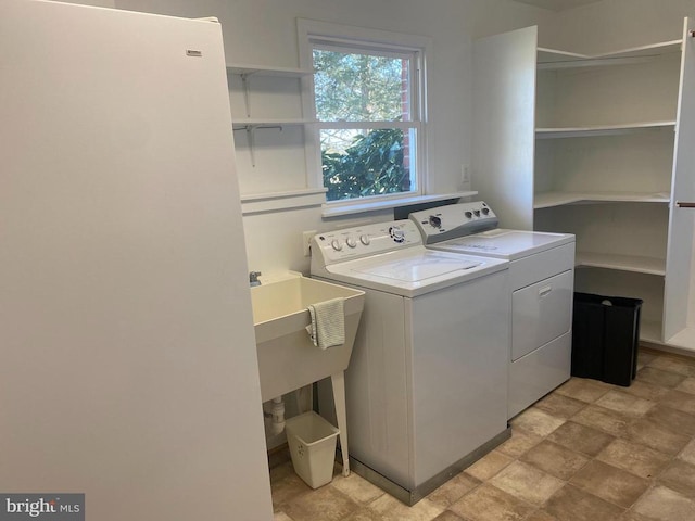  - laundry room featuring washer and dryer and stone finish floors