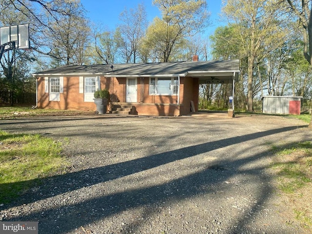  - single story home featuring asphalt driveway, a chimney, an attached carport, and brick siding