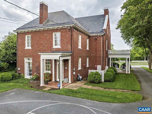 3809 Peakland Pl, Lynchburg, VA 24503 - view of home's exterior with a chimney, brick siding, a high end roof, and a yard