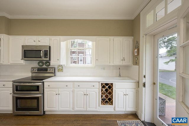 3809 Peakland Pl, Lynchburg, VA 24503 - kitchen featuring appliances with stainless steel finishes, white cabinets, backsplash, a sink, and crown molding