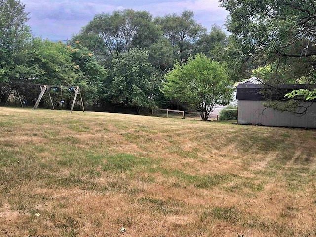 view of yard with an outdoor structure, a storage shed, and fence