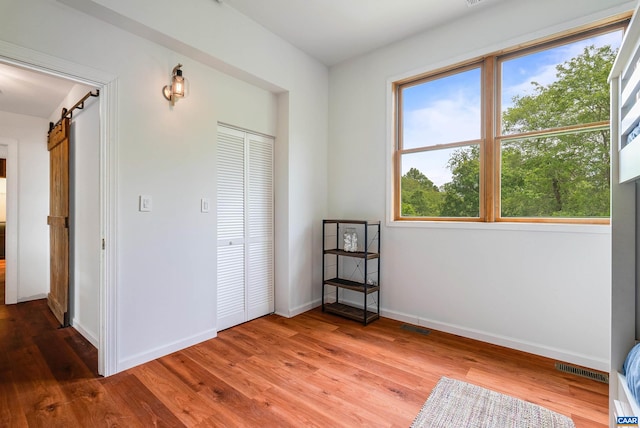 1900 Lowesville Rd, Amherst, VA 24521 - unfurnished bedroom featuring wood finished floors, a barn door, a closet, and baseboards