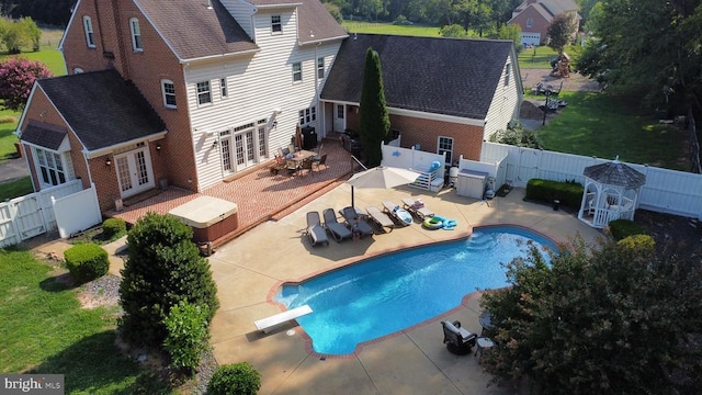 view of pool with a fenced in pool, a fenced backyard, french doors, a patio area, and a diving board