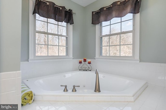 bathroom with a jetted tub and a wealth of natural light