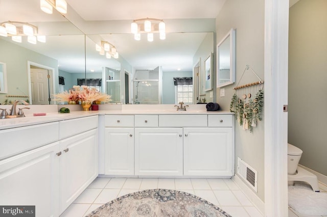 full bathroom featuring double vanity, visible vents, tile patterned flooring, a shower stall, and a sink