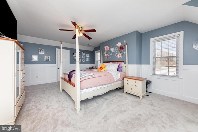 carpeted bedroom featuring a wainscoted wall and a ceiling fan