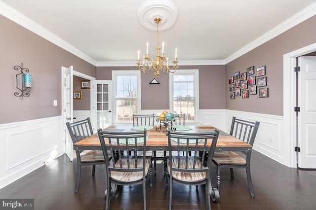 dining room with a wainscoted wall, dark wood finished floors, and a notable chandelier