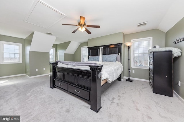 bedroom with lofted ceiling, visible vents, and light carpet