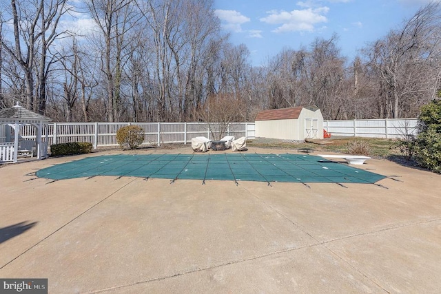 view of pool with a fenced in pool, a storage unit, fence, an outdoor structure, and a patio area