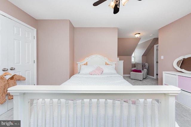 bedroom featuring ceiling fan, baseboards, vaulted ceiling, and light colored carpet