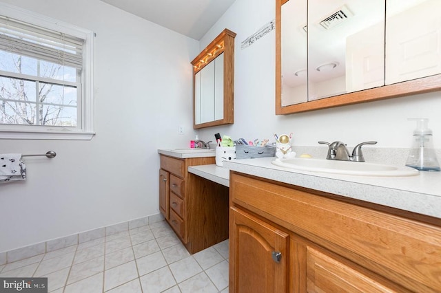 full bath featuring two vanities, tile patterned flooring, visible vents, and a sink