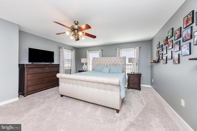 bedroom with ceiling fan, baseboards, and light colored carpet