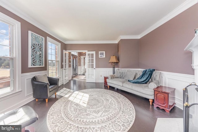 living area with a wainscoted wall, french doors, wood finished floors, and crown molding