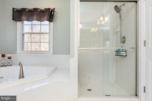 bathroom featuring a stall shower and a bath