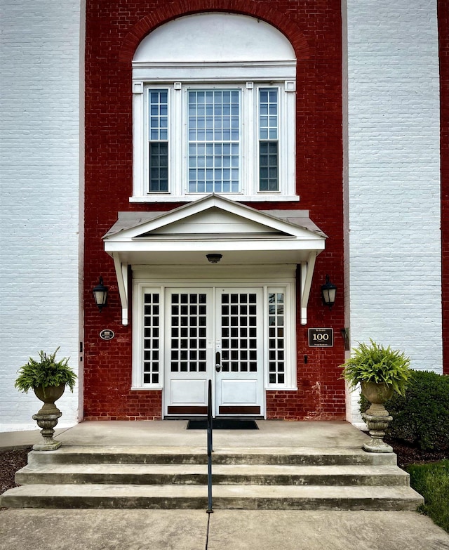 property entrance featuring brick siding and french doors