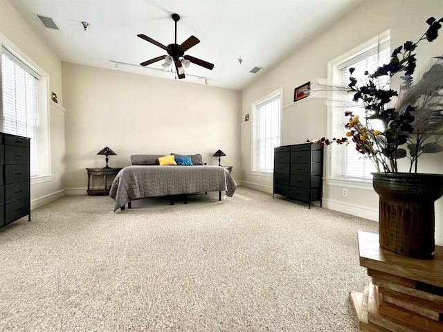 carpeted bedroom featuring visible vents, baseboards, and a ceiling fan