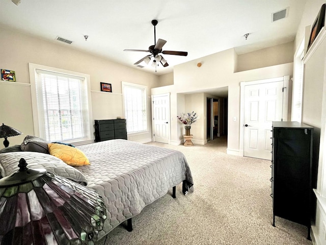 bedroom with visible vents, baseboards, ceiling fan, and light carpet