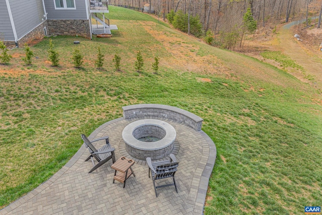view of green lawn featuring a fire pit and a patio area