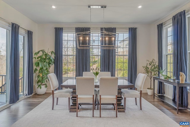 dining area featuring healthy amount of natural light, wood finished floors, a chandelier, and recessed lighting