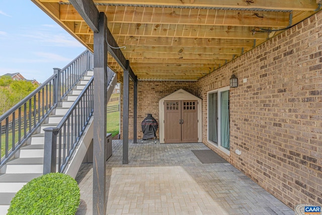 property entrance with brick siding and a patio area