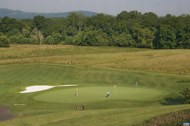 view of home's community with view of golf course and a mountain view