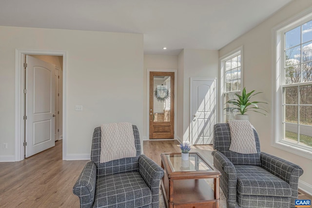 sitting room with healthy amount of natural light, wood finished floors, baseboards, and recessed lighting