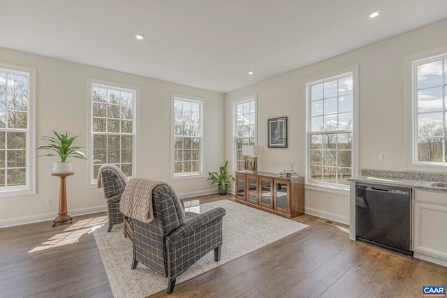 living area featuring hardwood / wood-style flooring, healthy amount of natural light, baseboards, and recessed lighting